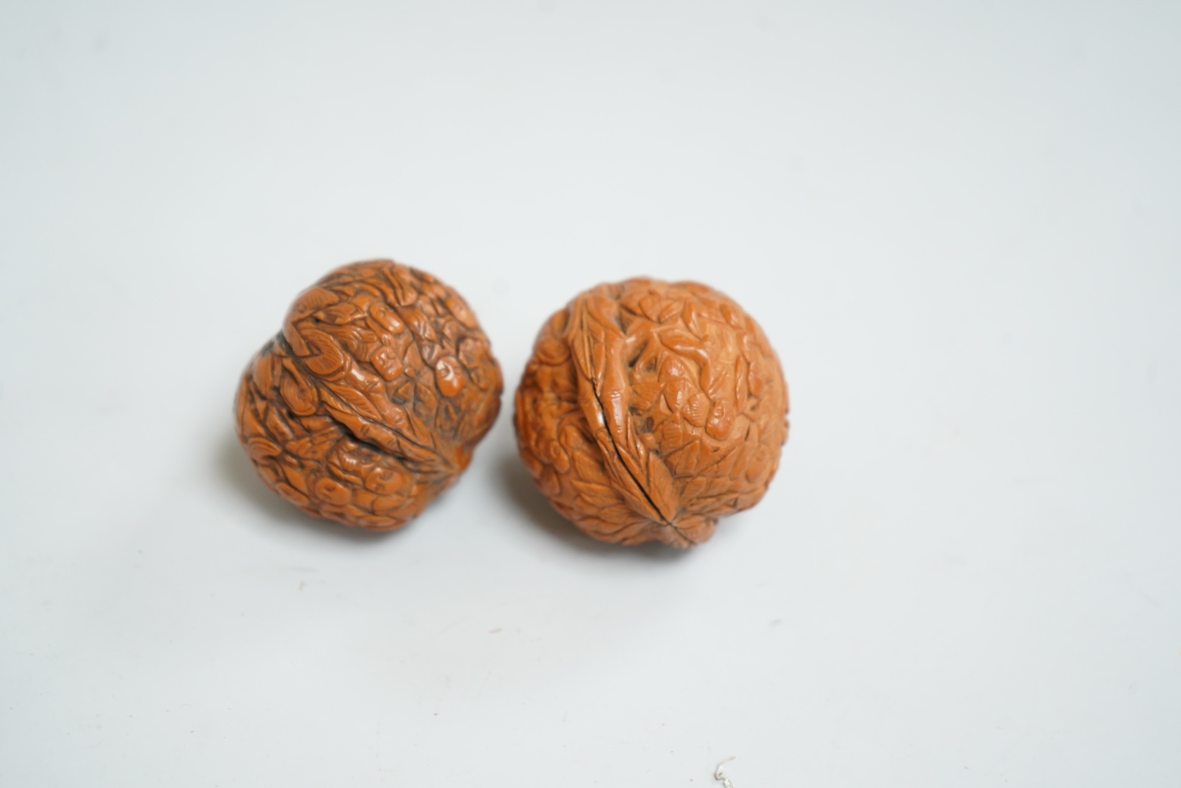 Two Chinese carved walnuts, approximately 4cm in diameter